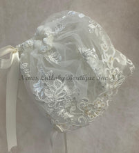 Load image into Gallery viewer, Embroidered lace bonnet with a ribbon on a neutral background